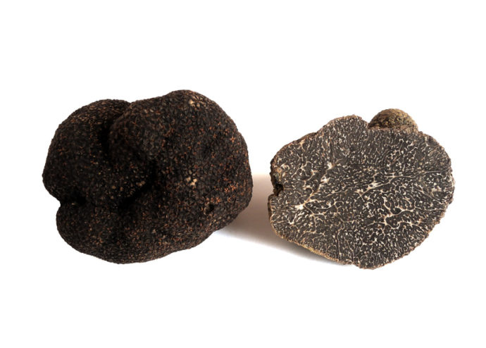 two black truffles, one is sliced